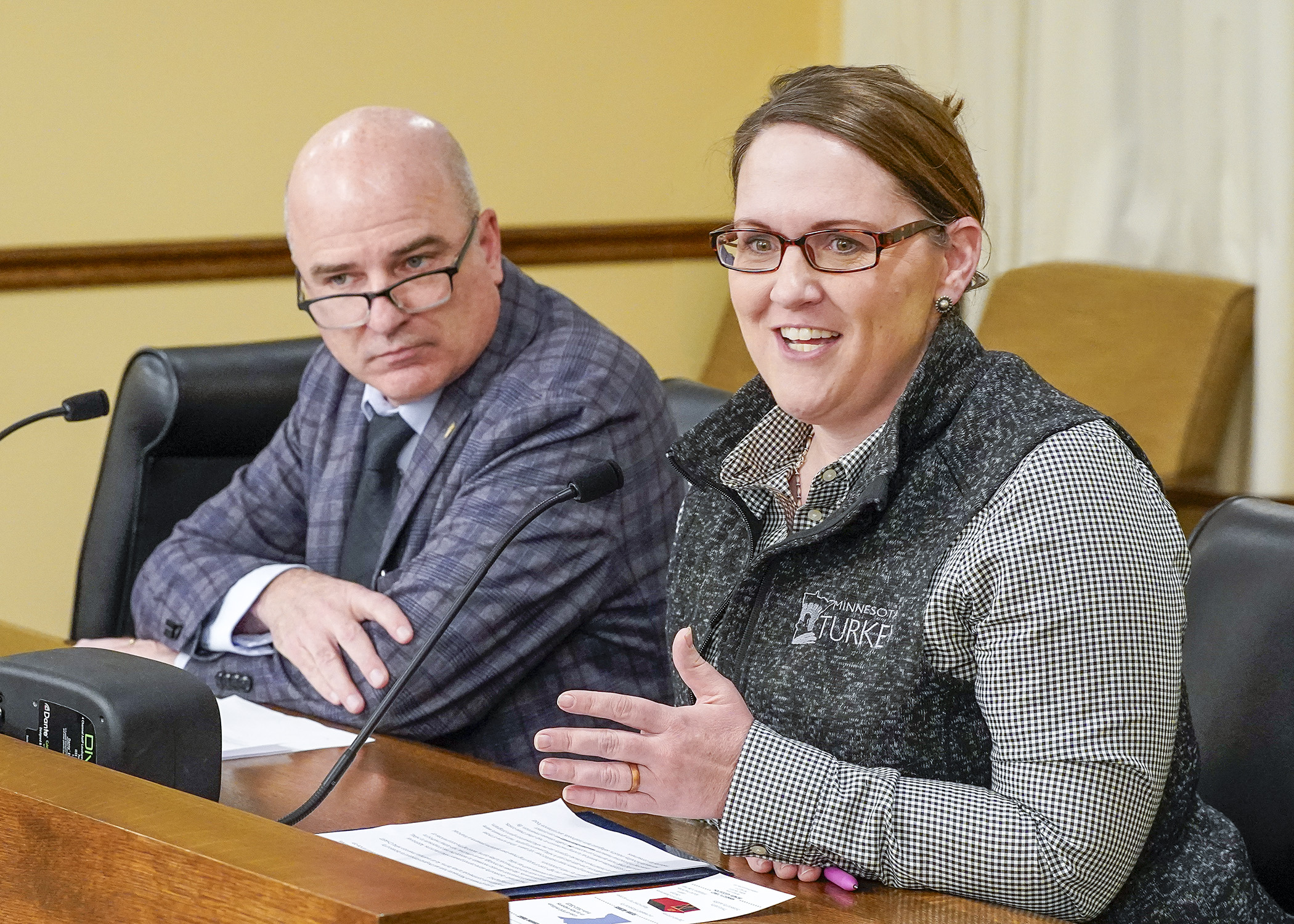 Ashley Kohls, executive director of the Minnesota Turkey Growers Association, testifies March 5 in support of a bill sponsored by Rep. John Burkel, left, that would establish a program to provide grants for poultry producers to prevent the spread of avian influenza. (Photo by Andrew VonBank)